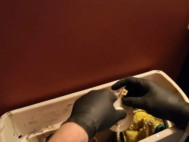 Hand working inside access panel on water shutoff piping for bathroom plumbing remodel in Stanton