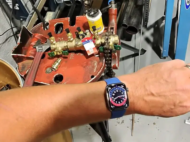 Hands working inside backflow preventer test assembly for backflow testing prevention in Stanton