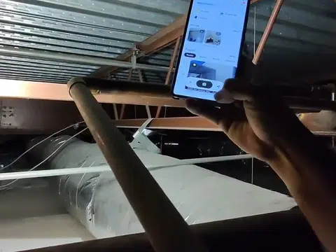 Commercial plumber working around overhead pipe runs for index in Stanton