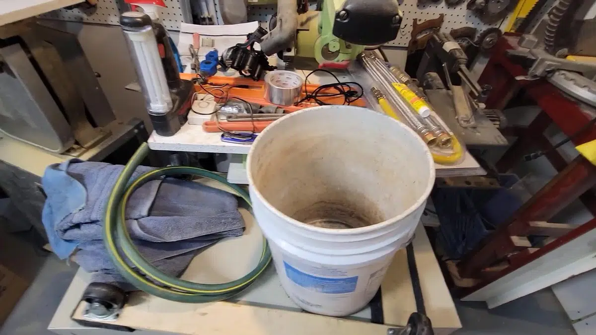 Bucket of dirty drain water beside cleaning equipment for santa ana in Santa Ana