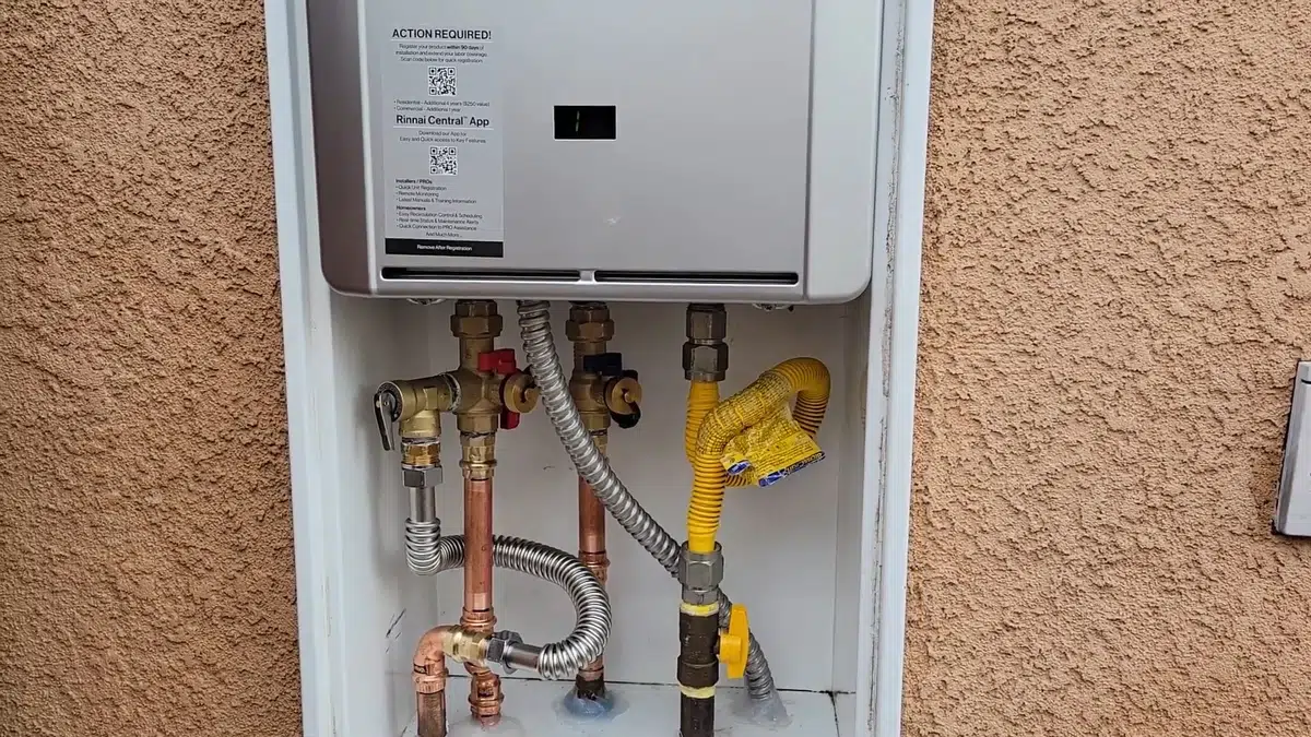 Exterior tankless water heater with gas and water lines for gas line in Stanton
