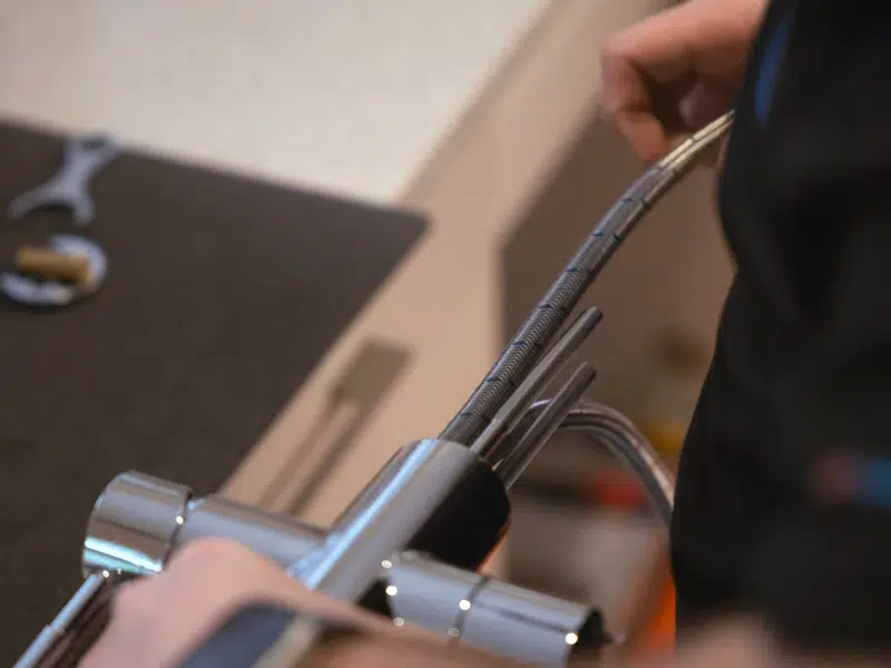 Chrome faucet connection being tightened with wrench for faucet sink repair in Stanton