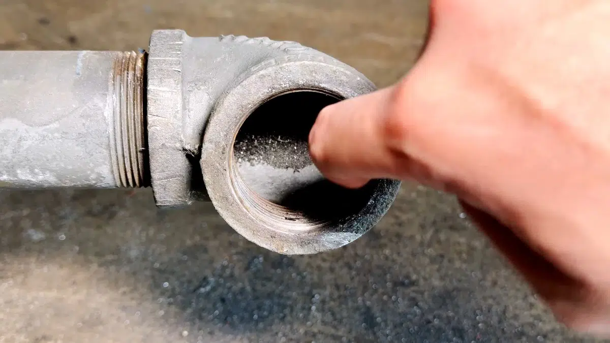 Finger inside open cast iron cleanout fitting for hydro jetting in Stanton