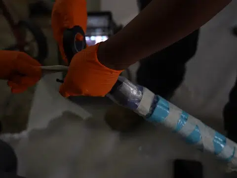 Technician handling pipe liner material at sewer repair access for plumbing blog index in Stanton
