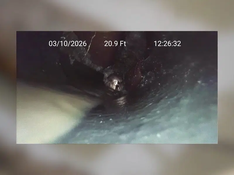 Green hose feeding into exposed sewer line outside for sewer line repair vs replacement orange county in Stanton shown from a different service angle