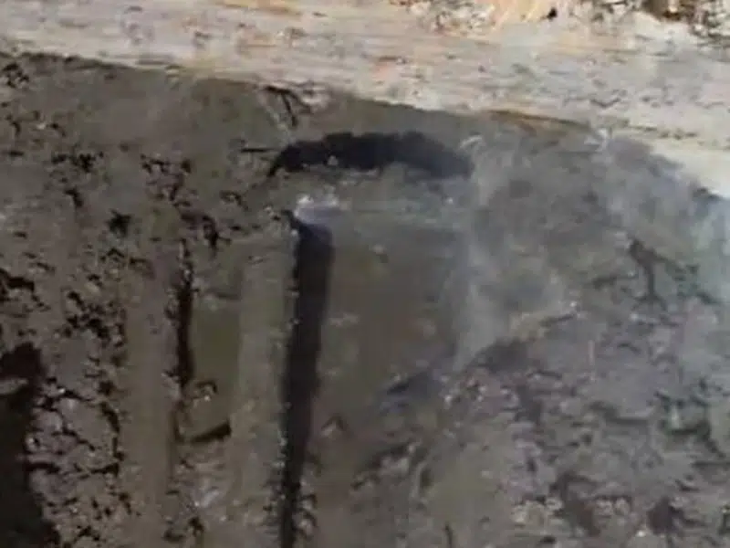 Vertical pipe exposed in narrow concrete opening for leak detection in Stanton