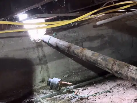 Tight crawlspace with exposed plumbing and insulation for index in Stanton shown from a different service angle