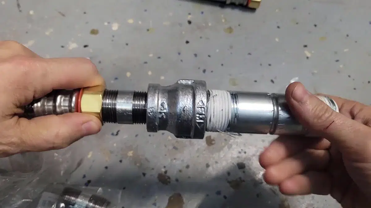 Black water heater coupling held between both hands for water heater replacement cost stanton in Stanton