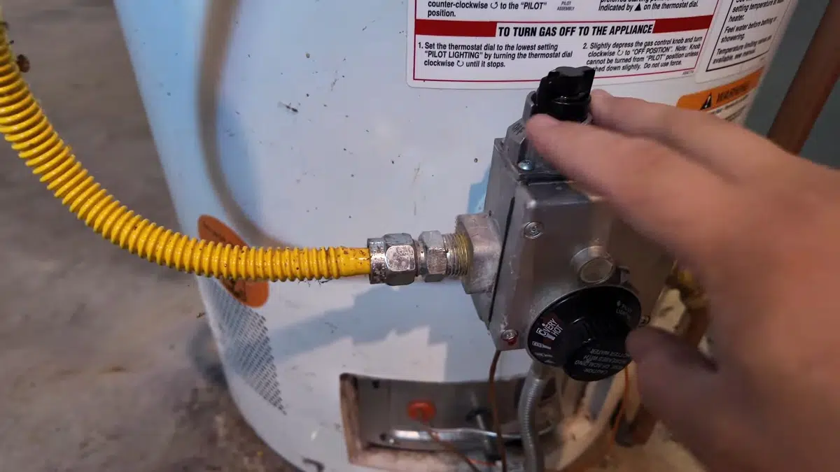 Yellow gas flex connector attached to water heater control for water heater repair in Stanton